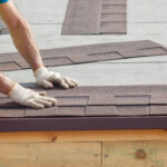 Roofer installing roof shingles on a home.